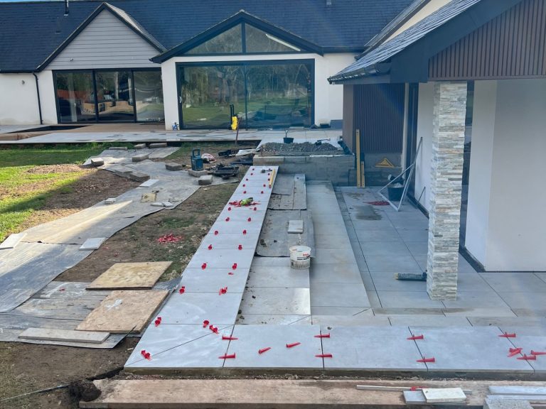 alpines Newly constructed patio with paving stones and surrounding landscaping work in progress.